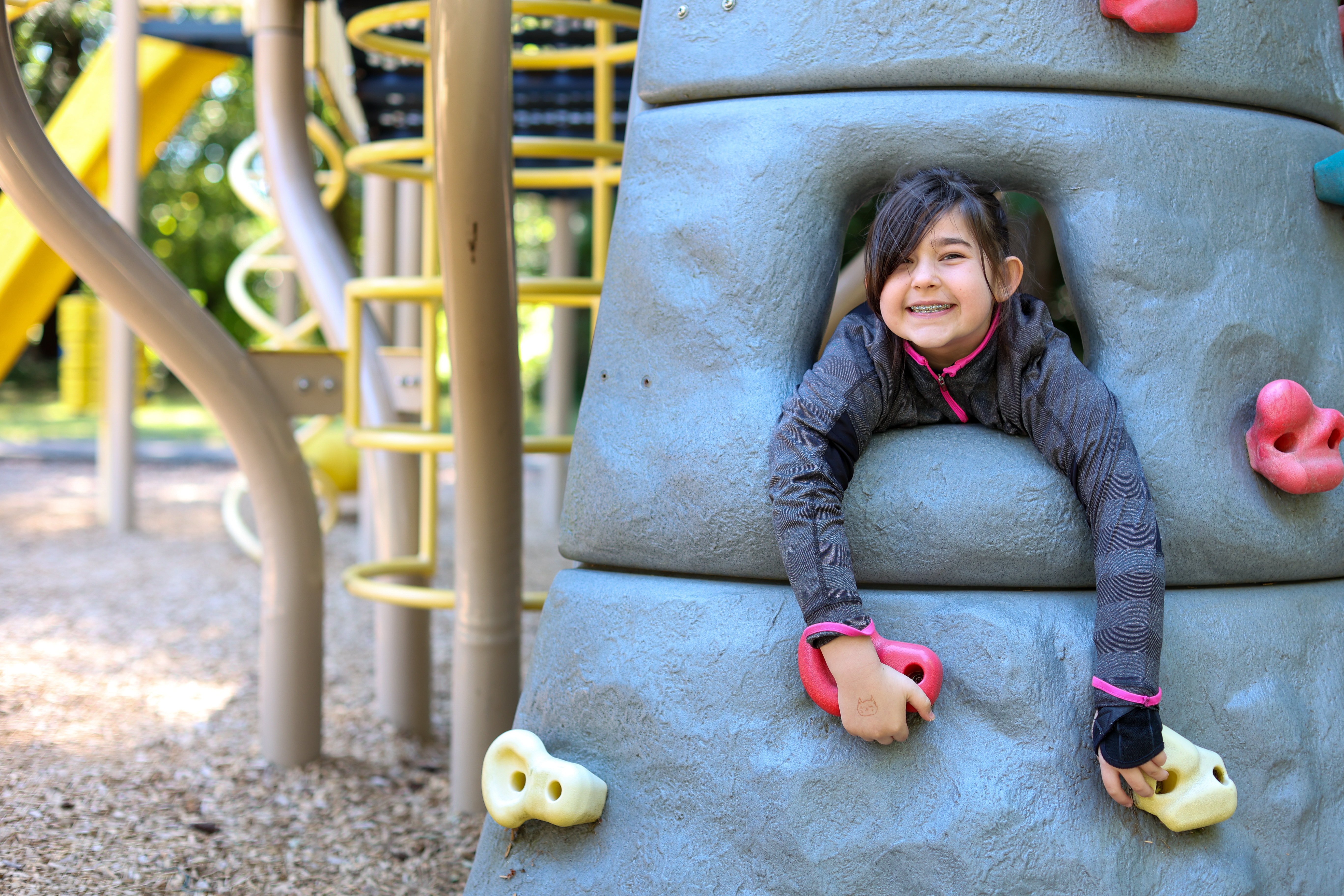 YMCA summer camper smiling from a play structure