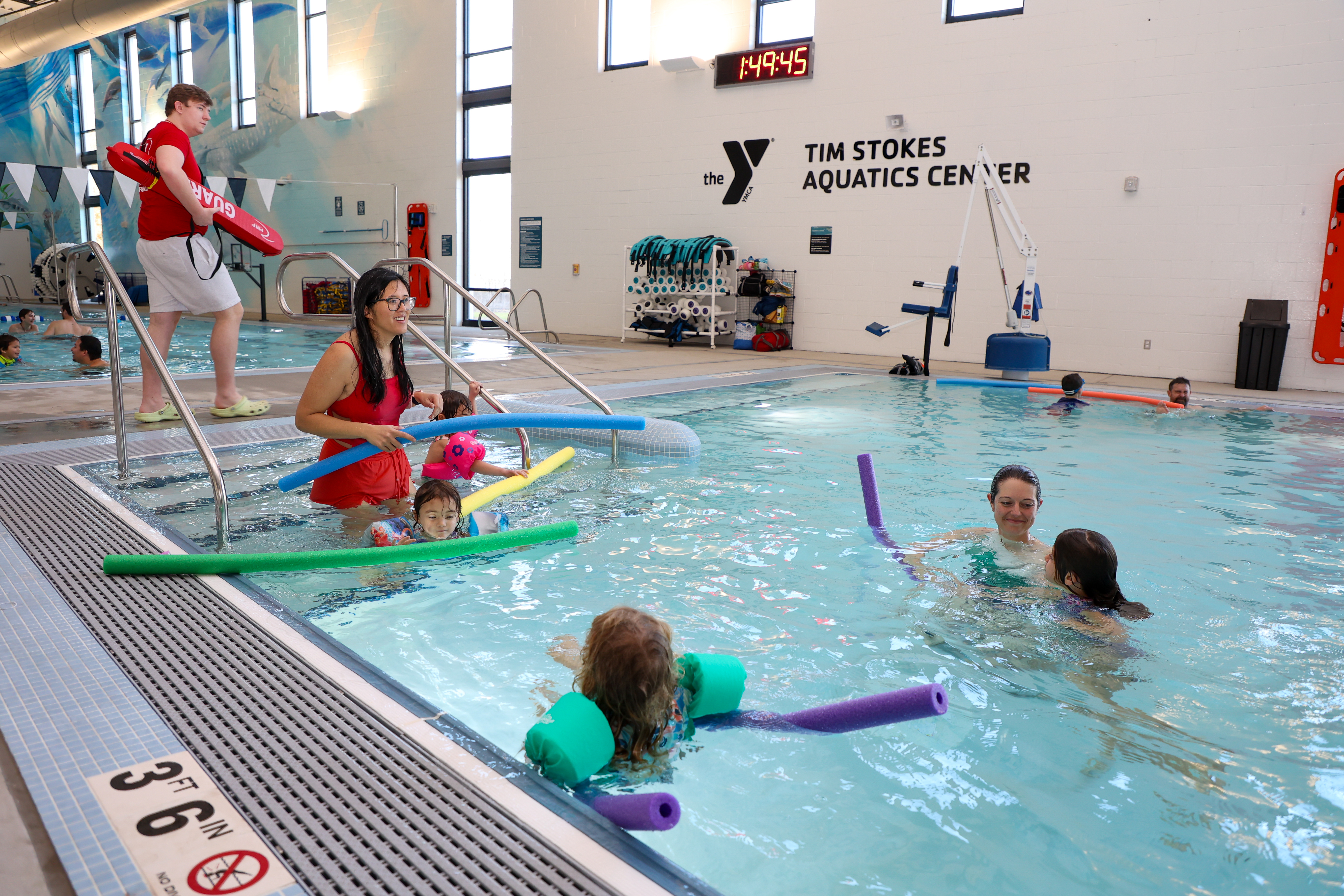 A family enters the small pool during Y Rec Swim