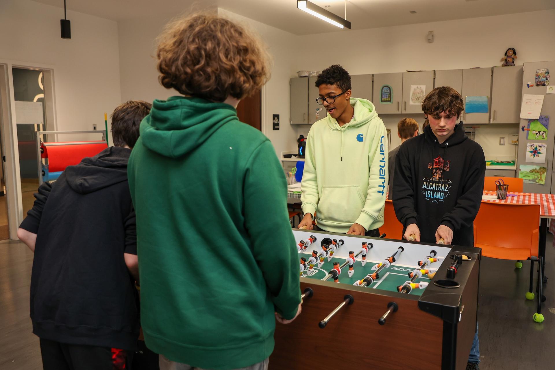 Teens play foosball in the corner hut