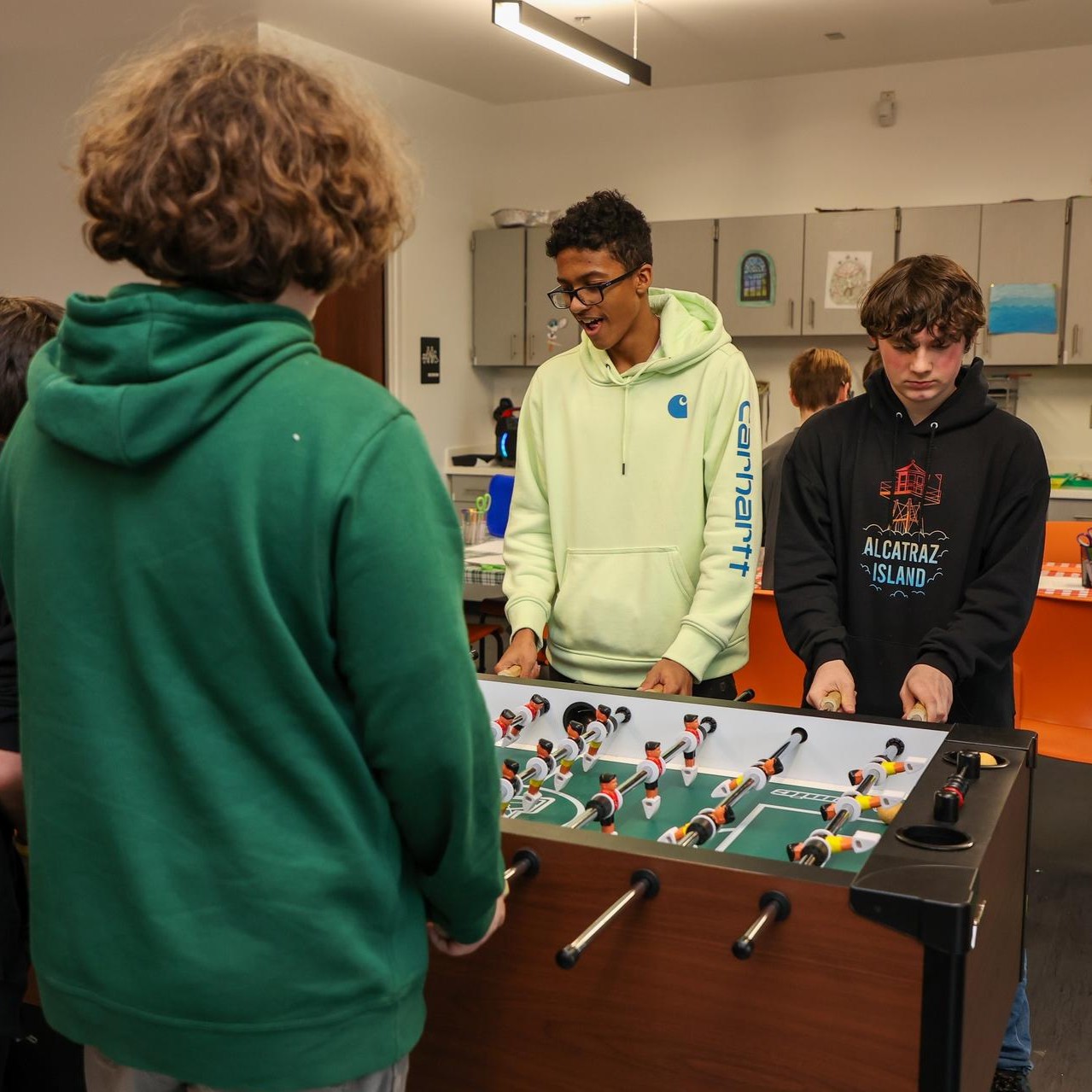 Teens play foosball in the corner hut