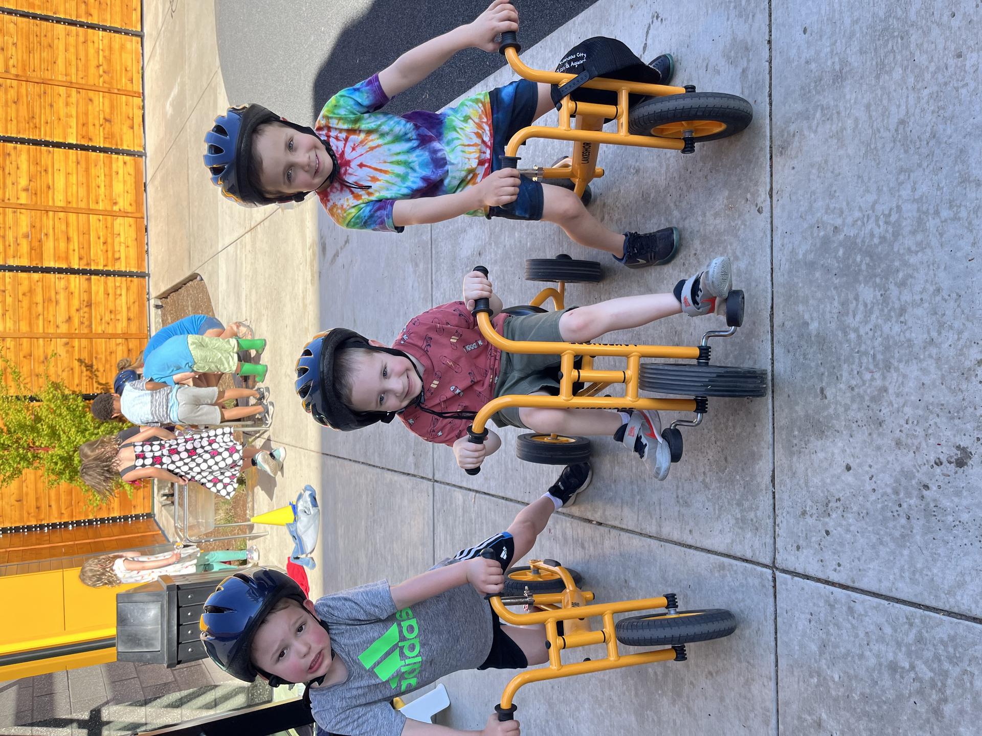 rainbows wear helmets while they push bike on the private playground