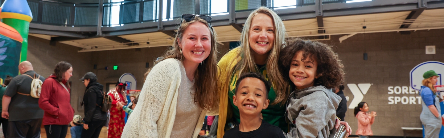 family smiles in the ymca gym during a family event