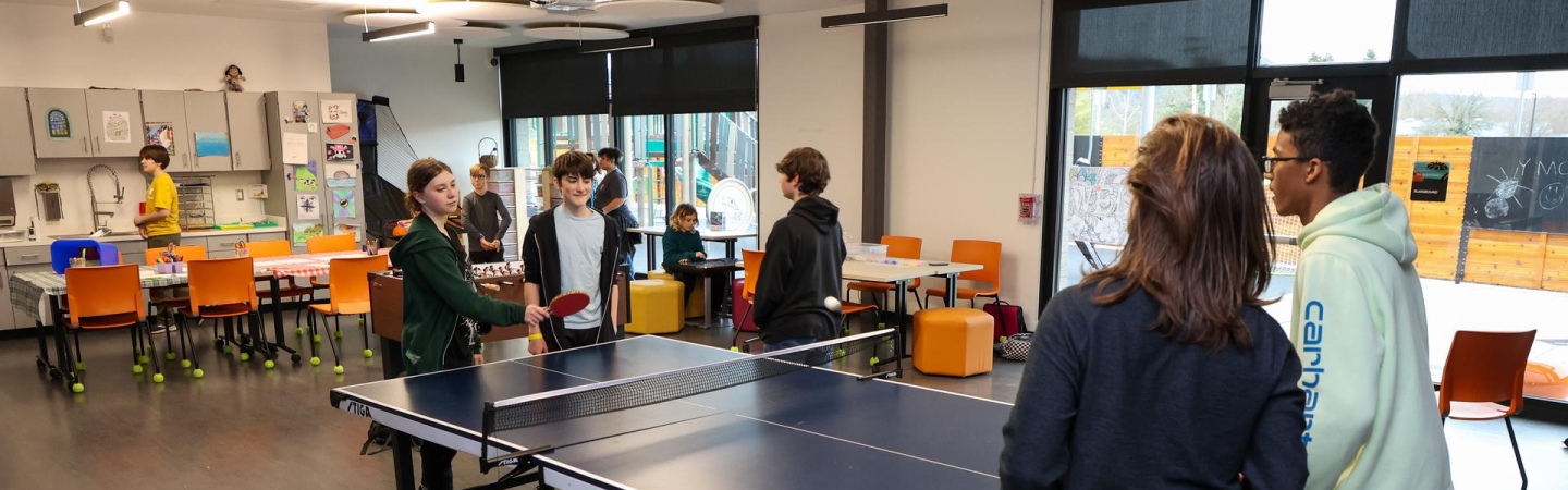 Creation Station and corner hut meet when the wall opens and middle and high students play ping pong as a group