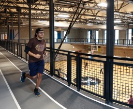 man jogging on indoor track