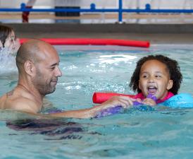 dad and daughter play in eugene ymca small pool during weekend rec swim