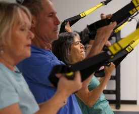 group performs a TRX exercise in a Y studio